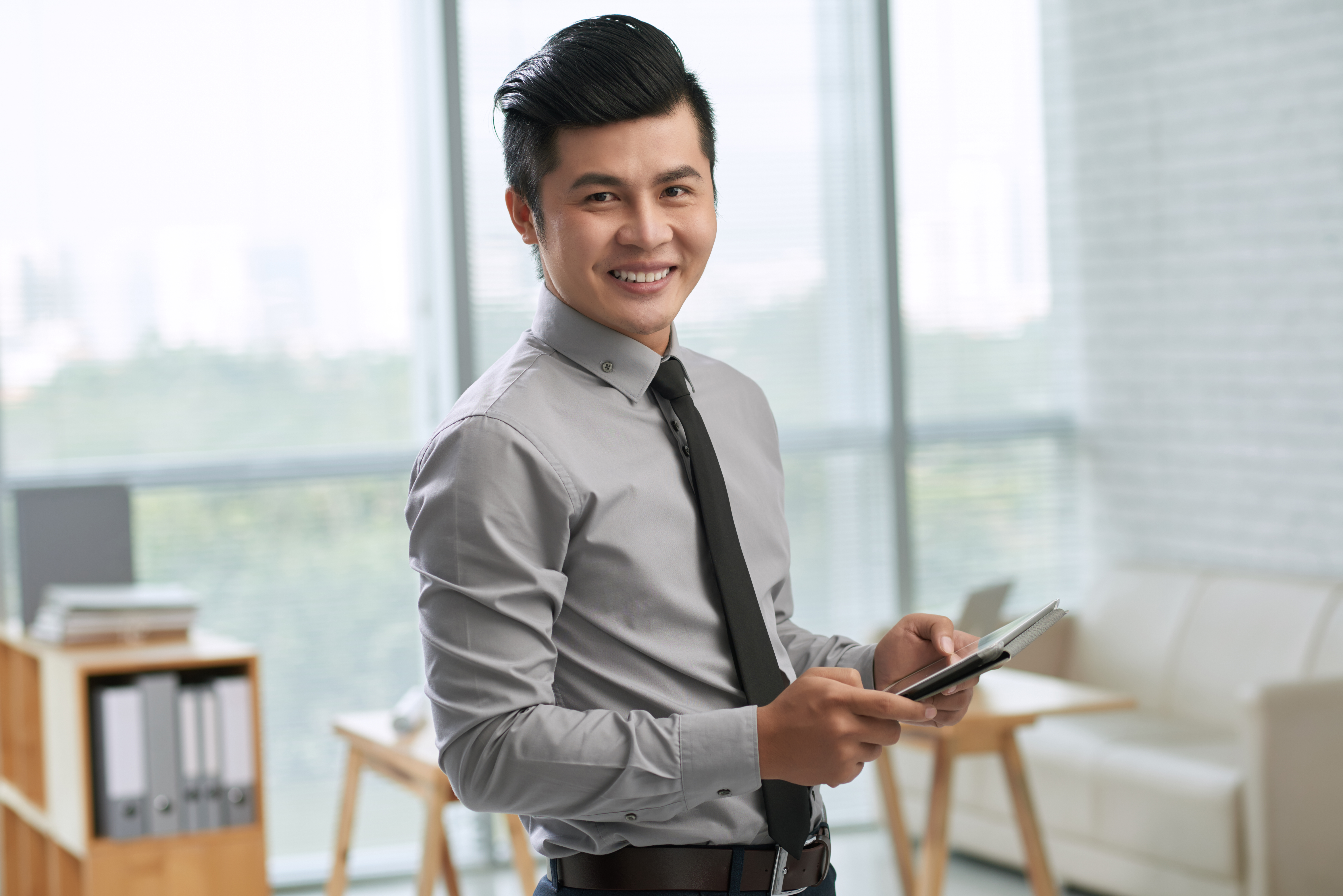 smiling-young-man-using-tablet-in-office-2026-01-08-05-49-59-utc